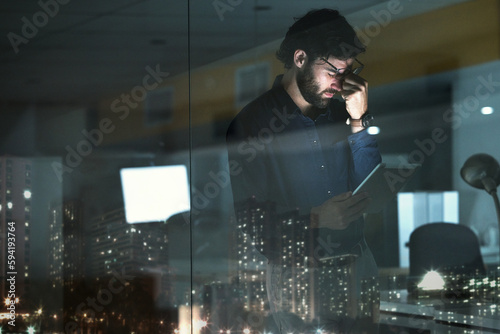 Business man, tablet and headache, pain or migraine in office by widow with city lights at night. Technology, fatigue or person with depression, brain fog or anxiety, stress or burnout with deadline.