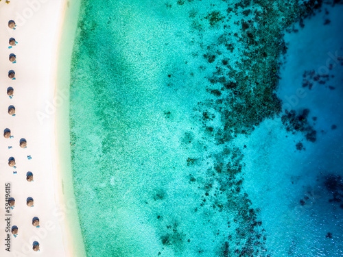 Aerial top down view of a tropical paradise beach with fine sand and turquoise sea the Maldives islands