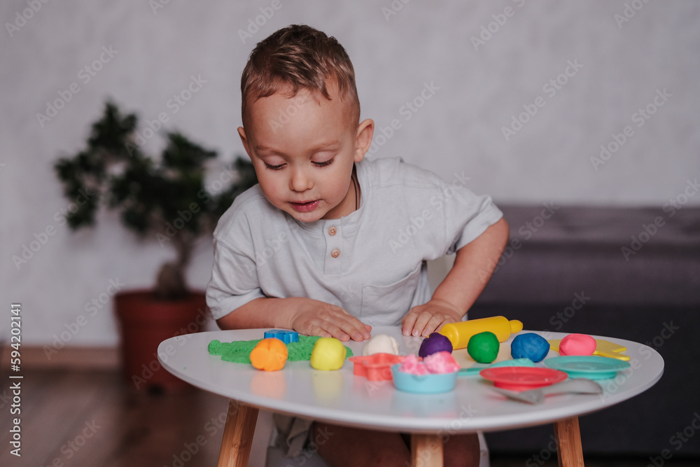 Cute toddler boy playing with play dough at home Cute toddler boy playing with play dough at home