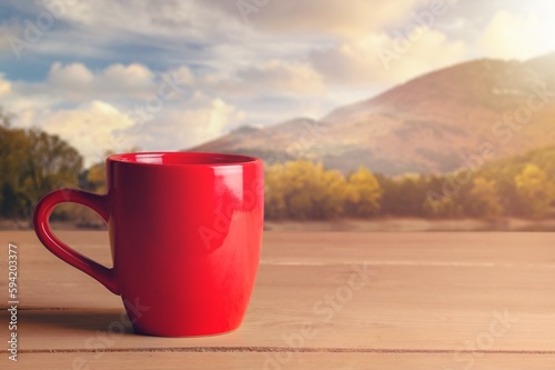 Tasty hot tea in cup in the sunrise background.
