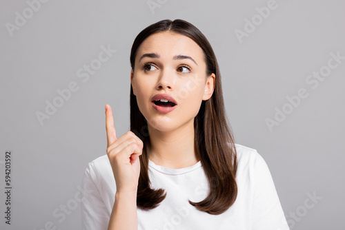 Close up shot selective focus on surprised screming woman in white shirt standing on white background looking into distance. photo