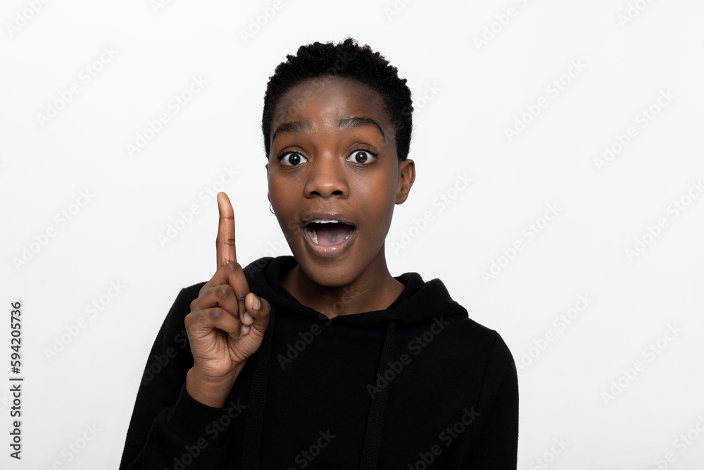 Happy dark skinned woman having idea and showing index forefinger while looking at camera over white background. Happy dark skinned woman having idea and showing index forefinger while looking at camera over white background.