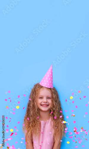 birthday little girl laughs rejoices throws confetti on blue background 