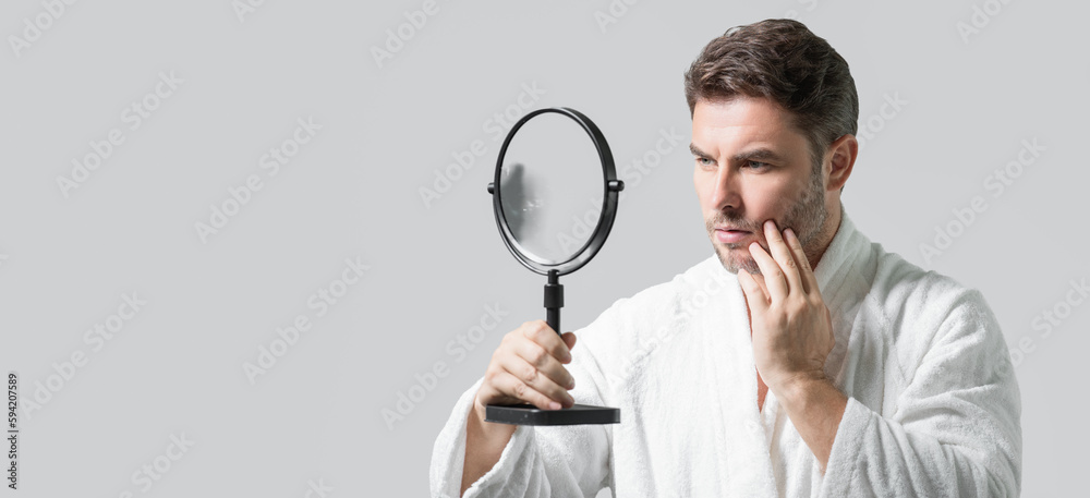 Banner with copy space of man touching chin and skin. Handsome man touching face in front of the mirror in bath. Perfect skin. Man cosmetic, skin treatment. Hygiene and skin care male face. Banner with copy space of man touching chin and skin. Handsome man touching face in front of the mirror in bath. Perfect skin. Man cosmetic, skin treatment. Hygiene and skin care male face.