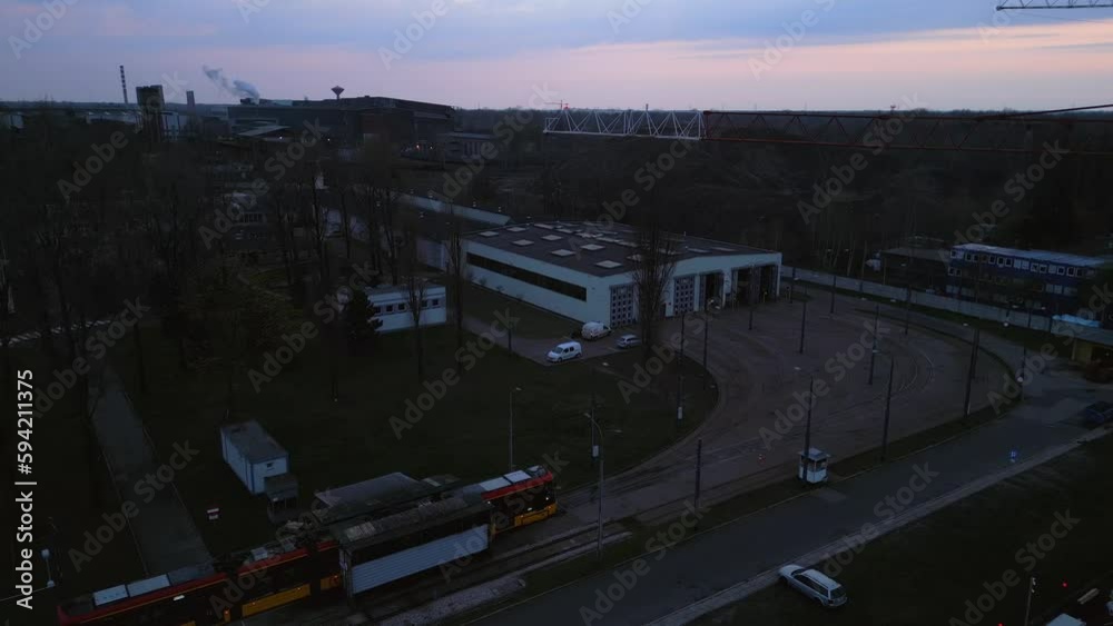 An aerial shot of a tramway arriving at a stop for inspection, with a metal smelter in the background during sunset. An aerial shot of a tramway arriving at a stop for inspection, with a metal smelter in the background during sunset.