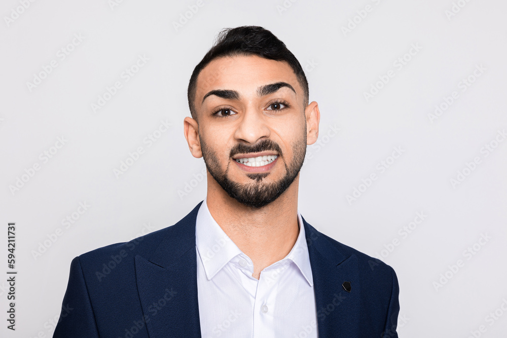 Portrait of happy delighted turkish man in studio isolated over grey background looking at camera smiling with white teeth buisneesman young successful guy.