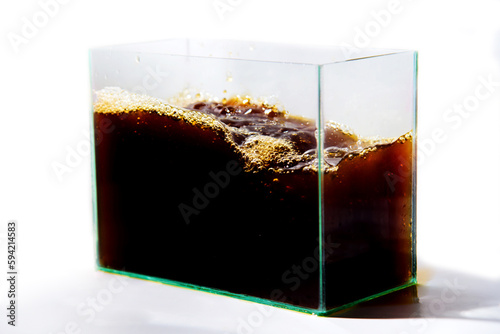 cola in a glass container on a white background, close-up