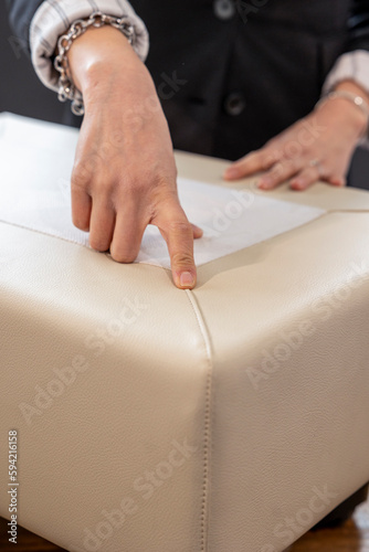 Una mano indica la cucitura dela pella di un divano 