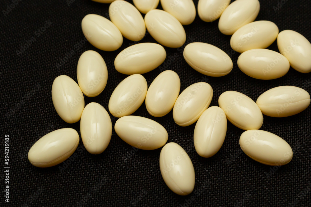 Macro Close up of white painkiller tablet on a reflective black background Macro Close up of white painkiller tablet on a reflective black background