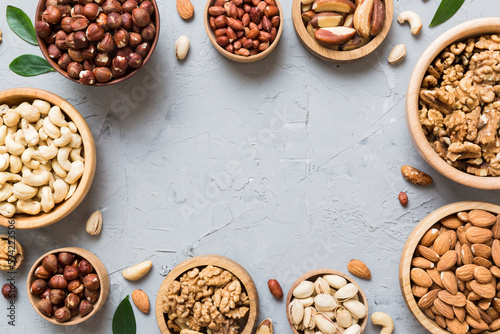 mixed nuts in wooden bowl. Mix of various nuts on colored background. pistachios, cashews, walnuts, hazelnuts, peanuts and brazil nuts