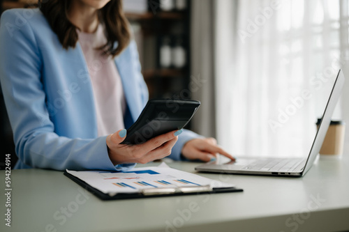 businesswoman working with digital tablet computer and smart phone with financial business strategy layer effect on desk