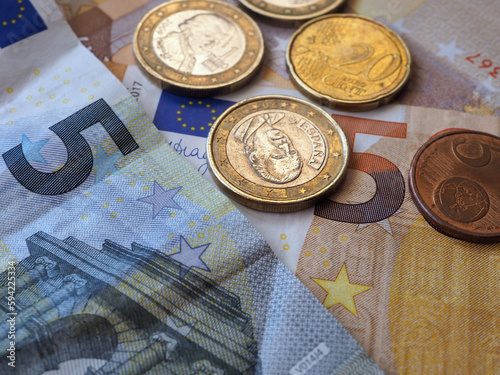 Euro coins on heap of euro bills