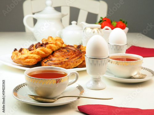 Breakfast with egg, tee, milk, buns, strawberry photo