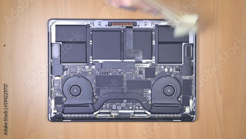 Cleaning dirty interior of a laptop with canned air and soft brush.