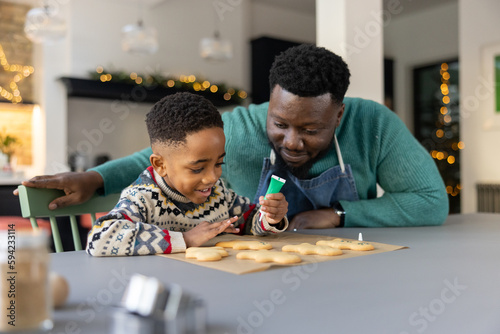 Father and Son decorating gingerbread men together at Christmas