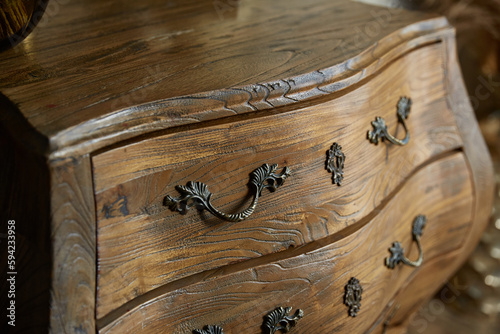 Vintage curved chest of drawers close-up. Forged handles