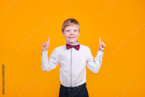 I have idea. Child boy with fingers up on yellow background