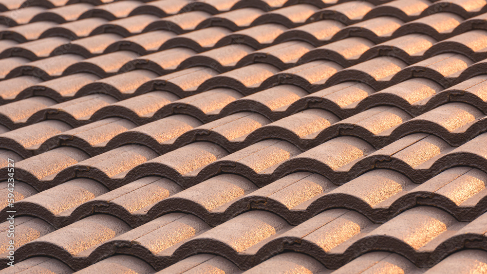 Background of gray concrete tiles roof pattern with golden sunlight reflection on surface