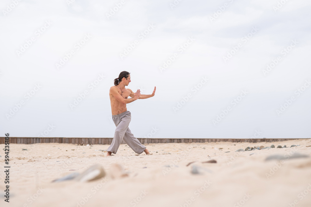 Caucasian man practices martial arts outdoors. balance and meditation. Caucasian man practices martial arts outdoors. balance and meditation.