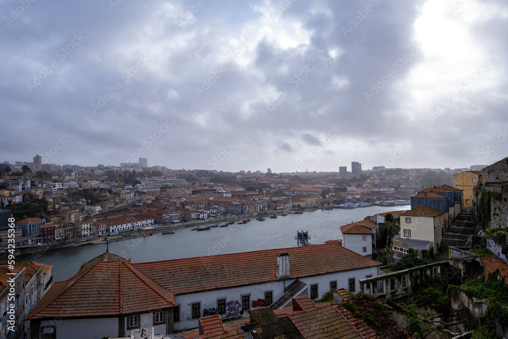 Panorámica de la ciudad de Oporto con el río cruzando por medio de las casas en un día nublado de primavera.