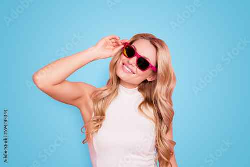 Portrait of lovely positive stylish girlfriend with beaming smile, fashionable successful confident chick in summer glasses holding eyelet with hand isolated on pink background