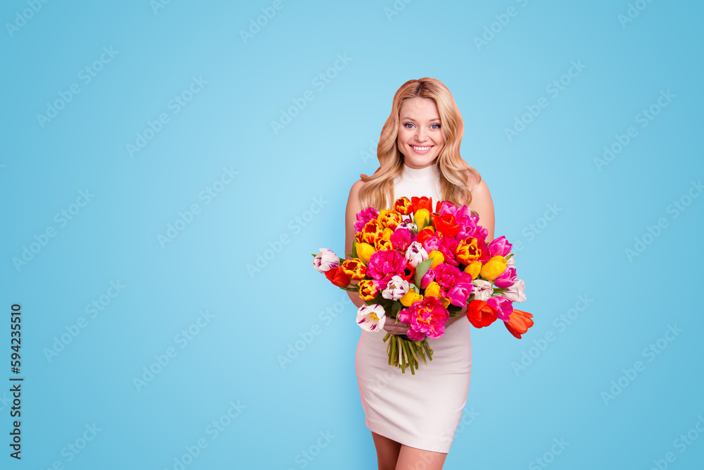 Portrait of pretty elegant sexy slim woman in white dress having big bouquet of tulips in hands looking at camera isolated on pink background with copyspace