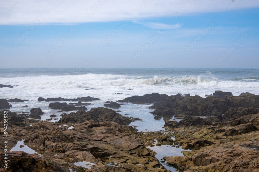 El océano Atlántico revuelto rompiendo las olas entre las rocas de la ciudad de Oporto en un día de primavera.