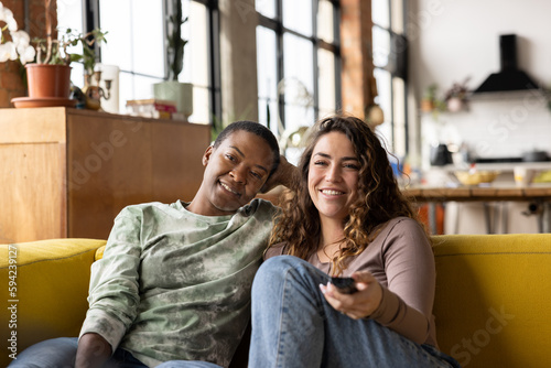 Female Friends watching Television in a loft apartment