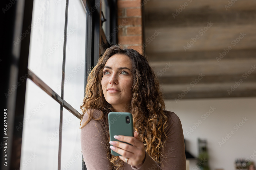 Young adult female using a Smartphone in loft apartment Young adult female using a Smartphone in loft apartment