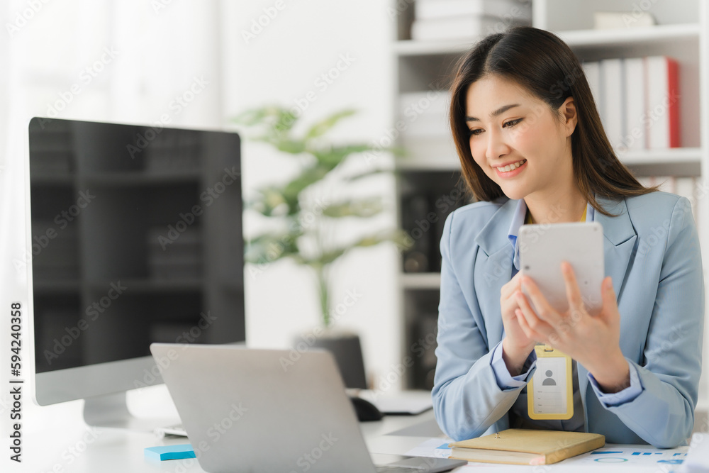 Asian businesswoman in formal suit in office happy and cheerful during using smartphone and working Asian businesswoman in formal suit in office happy and cheerful during using smartphone and working