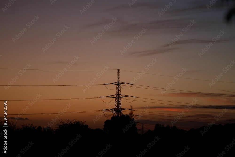 A silhouette of cable towers at sunset