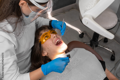 Dentist checks for violations in the natural bite after treatment with articulation paper. Adjustment of the seal after installation.
