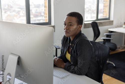 Young African American businesswoman working at a desktop computer in an office