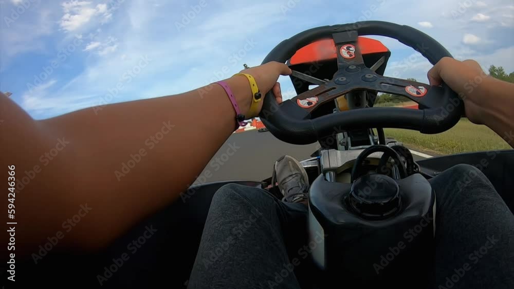 A boy drives a kart on a race track in an amusement park