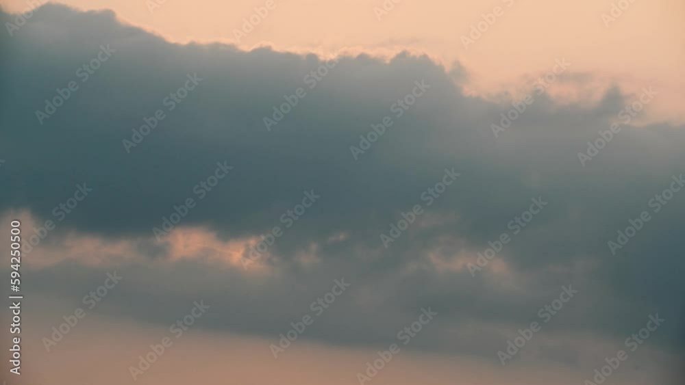 The sunset sun was covered by clouds and then revealed again. A view of the changing sun clouds in the sky at dusk. The sunset sun was covered by clouds and then revealed again. A view of the changing sun clouds in the sky at dusk.
