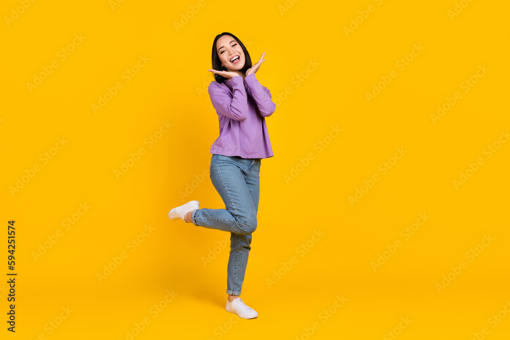 Full length photo of excited pretty woman wear violet shirt arms face smiling empty space isolated yellow color background
