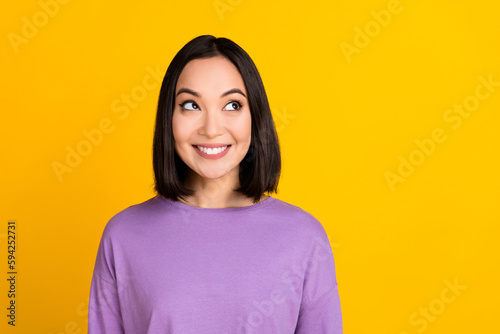 Photo of dreamy positive lady dressed purple shirt looking empty space isolated yellow color background