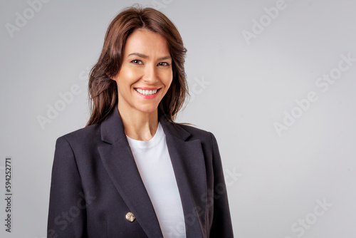 Portrait of a brunette mid aged woman standing at isolated background
