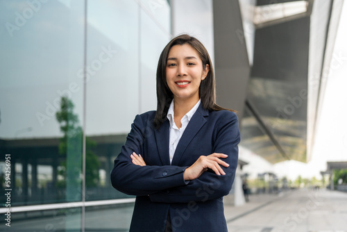 Portrait beautiful Businesswoman in suit standing at the buildings downtown. Confident woman looking towards their goals for success. Executive Smart businessman