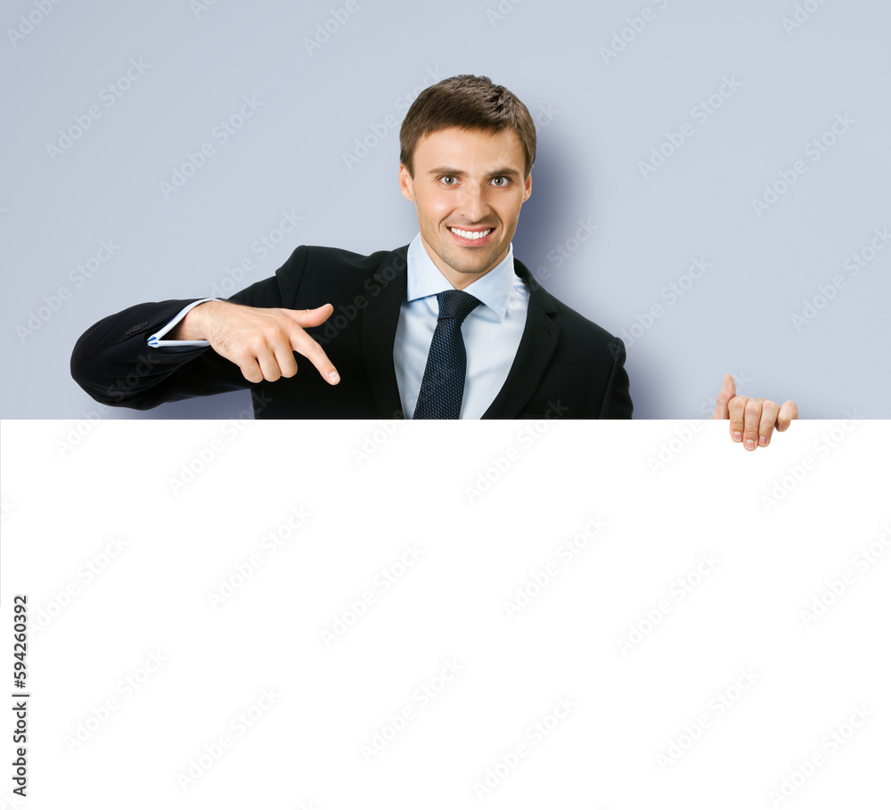 Image of business man professional bank manager in confident black suit. Businessman stand behind, hang over, show point finger empty white banner signboard. Isolated on grey gray background Image of business man professional bank manager in confident black suit. Businessman stand behind, hang over, show point finger empty white banner signboard. Isolated on grey gray background