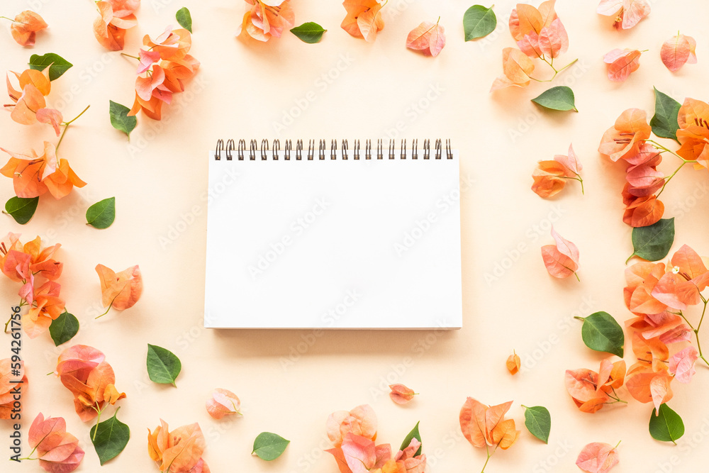 open blank notepad with orange bougainvillea flowers