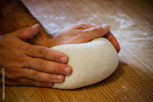 panadero tradicional dando forma a la masa antes de hornear photo