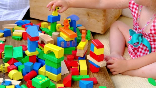 smart little child, girl 3 years old playing with educational toy, wooden geometric figures, blocks, kindergarten games, concept of childhood, earlier child development, creativity, early training