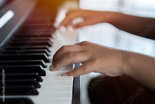 Hands of the child on the piano keys. Selective focus. Music abilities for kids.