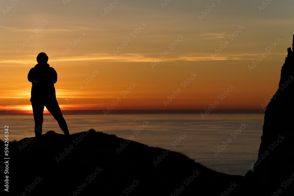 silhouette of a person at the sea at sunset