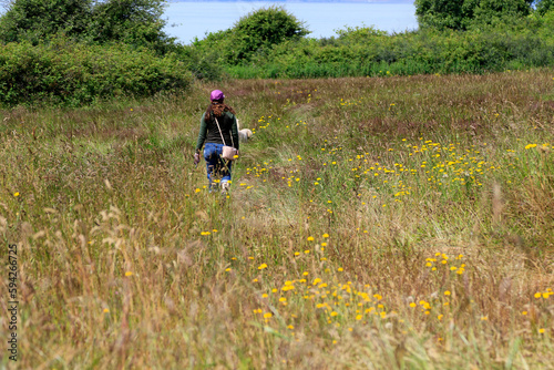 Jeune femme marchant dans un champ de fleurs sauvages