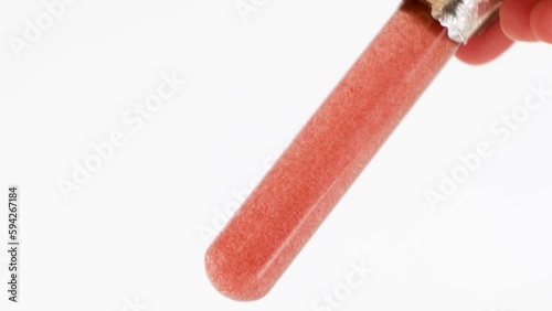Haematococcus pluvialis in test tube with clear liquid. Astaxanthin, protection of UV-radiation, antioxidant. Abstract body care cosmetics photo