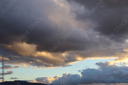 Dramatic Sky with Grey Clouds and Orange Sky around Sunset Time about to Rain With A Silhouette of Mountain