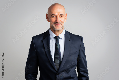 Confident businessman wearing suit and tie agains isolated background