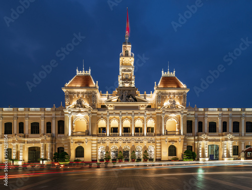 Traffic in front of Ho Chi Minh City Hall, Saigon City Hall or Committee Head office in the evening, Vietnam. Light trail and night. Popular place to visit in Saigon. Travel destinations in Vietnam photo